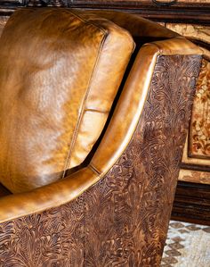 a brown leather chair sitting on top of a rug