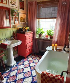 a bathroom with a bathtub, sink and red cabinet in it's center