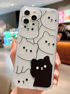 a person holding up a phone case with cats on it