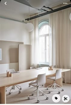 an office with white chairs and a large wooden table