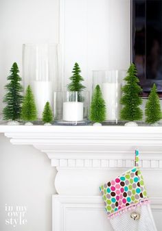 a mantle with candles and christmas trees on it