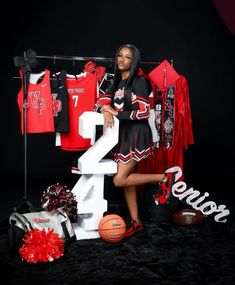 a woman posing in front of some sports shirts