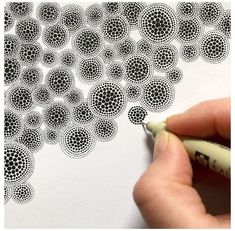 someone is drawing circles on paper with a marker