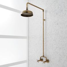 a shower head and hand shower in a white tiled bathroom with gold faucet