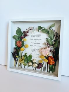 a white frame with flowers and leaves on the inside that says, i do not know what this is