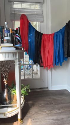 there is a colorful streamer hanging from the ceiling in front of a door with bottles and vases on it