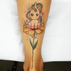 a woman's leg with a tattoo on it that has a little unicorn sitting on top of a flower