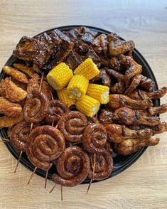 an assortment of meats and corn on the cob