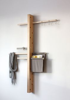 a coat rack with two coats hanging on it and a bucket in the bottom right corner