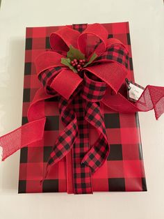 a present wrapped in red and black checkered paper with a bow on the top