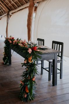 a long table with flowers and greenery on it