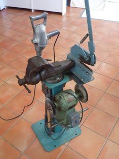 an old machine is sitting on the ground in front of a tile floor and wall