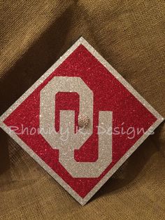 a red and white diamond shaped patch with the letter q on it