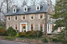 a stone house with wreaths on the windows