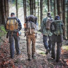 three men with backpacks walking in the woods