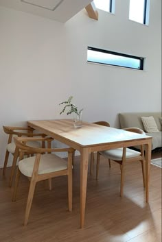 a wooden table sitting in the middle of a living room next to a couch and window