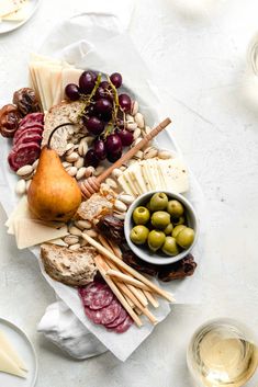 an assortment of cheeses, meats and olives on a platter