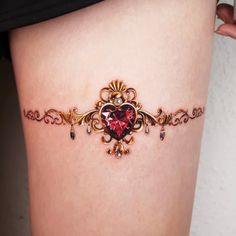 a close up of a person's thigh with a heart shaped tattoo on it