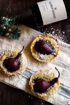 three desserts on a napkin next to a bottle of wine