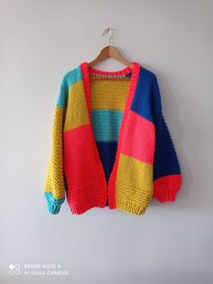 a colorful sweater hanging on a white wall