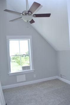 an empty room with a ceiling fan and window