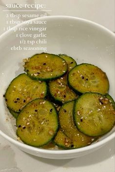 a white bowl filled with sliced cucumbers on top of a table