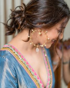 a woman in a blue sari is looking at her cell phone