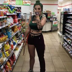 a woman with green hair and makeup is standing in a store