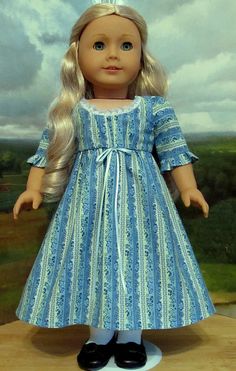 a doll with blonde hair wearing a blue dress