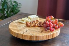 grapes, nuts and cheese on a bamboo cutting board