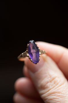 Very pretty handmade 10k gold ring with a purple synthetic glass stone, that is to look like an amethyst. The gem has some wear to it on the surface, but no chips. The style looks like it might have had an alaskan black diamond, and replaced with the purple stone. Very unique looking  ring! size 8.25 2.5 grams stone size 20mm x 7mm 👋🏽 We charge an additional $50 if you are interested in having this ring resized. There is a 2 week (or less) turn around time. Please go to this listing https://ww Heirloom Amethyst Jewelry As Birthstone, Marquise Amethyst Ring Gemstone Gift, Marquise Amethyst Ring Gift, Marquise Amethyst Ring As Gift, Gift Marquise Amethyst Ring, Oval Amethyst Jewelry Collectible, Marquise Amethyst Jewelry Gift, Gold Marquise Amethyst Ring, Marquise Amethyst Jewelry For Gift