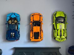 three toy cars are hanging on the wall