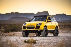 a yellow four - door suv is parked in the desert