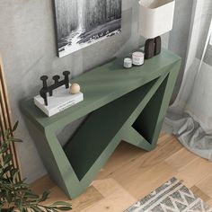 a green console table with two candles on it and a painting in the corner behind it