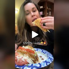 a woman eating a sandwich on top of a blue and white plate with the caption crunchy tacos