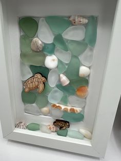 sea glass and shells in a white frame