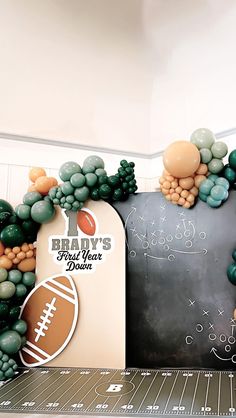 a football themed party with balloons and chalkboards on the wall, along with an inflatable football