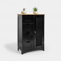 a black cabinet with two white vases on top