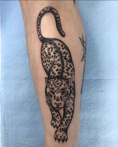 a tattoo on the leg of a person with a leopard in it's body