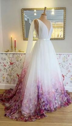 a wedding dress on display in front of a mirror with flowers and leaves all over it