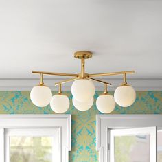 three lights are hanging from the ceiling in a room with green and blue wallpaper