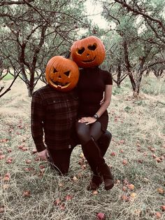 a man and woman with pumpkins on their heads