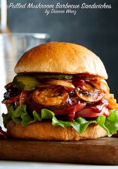 a grilled mushroom, bacon and lettuce sandwich on a wooden cutting board