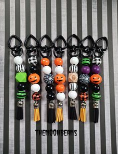 halloween themed key chains with pumpkins, jack - o - lanterns and tassels