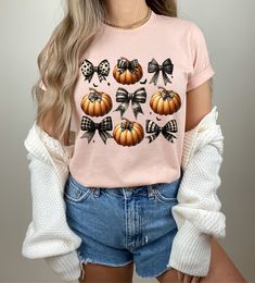 The Coquette Halloween Pumpkin Bow Shirt is a stylish and festive addition to your Halloween wardrobe. Featuring a charming pumpkin design adorned with a bow, this trendy shirt is the perfect Halloween gift for any fashion-forward individual. Whether you prefer a cozy sweater or a retro-inspired shirt, this piece effortlessly combines comfort with seasonal flair. Embrace the spirit of Halloween with this delightful and eye-catching shirt that promises to bring a touch of fun to your celebrations Fall Cotton Top With Bow Detail, Baby Blue Shirt, Pumpkin Sweater, Coquette Halloween, Bow Shirt, Halloween Bows, Bow Shirts, Trendy Halloween, Trendy Shirts