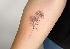 a small flower tattoo on the arm