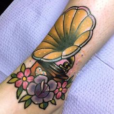 a woman's foot with a tattoo on it that has an image of a vase and flowers