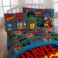 a bed covered in comic themed sheets and pillows