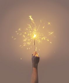 a hand holding a sparkler in the air