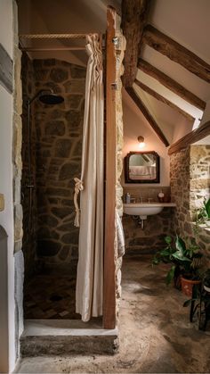 a bathroom with stone walls and exposed ceiling